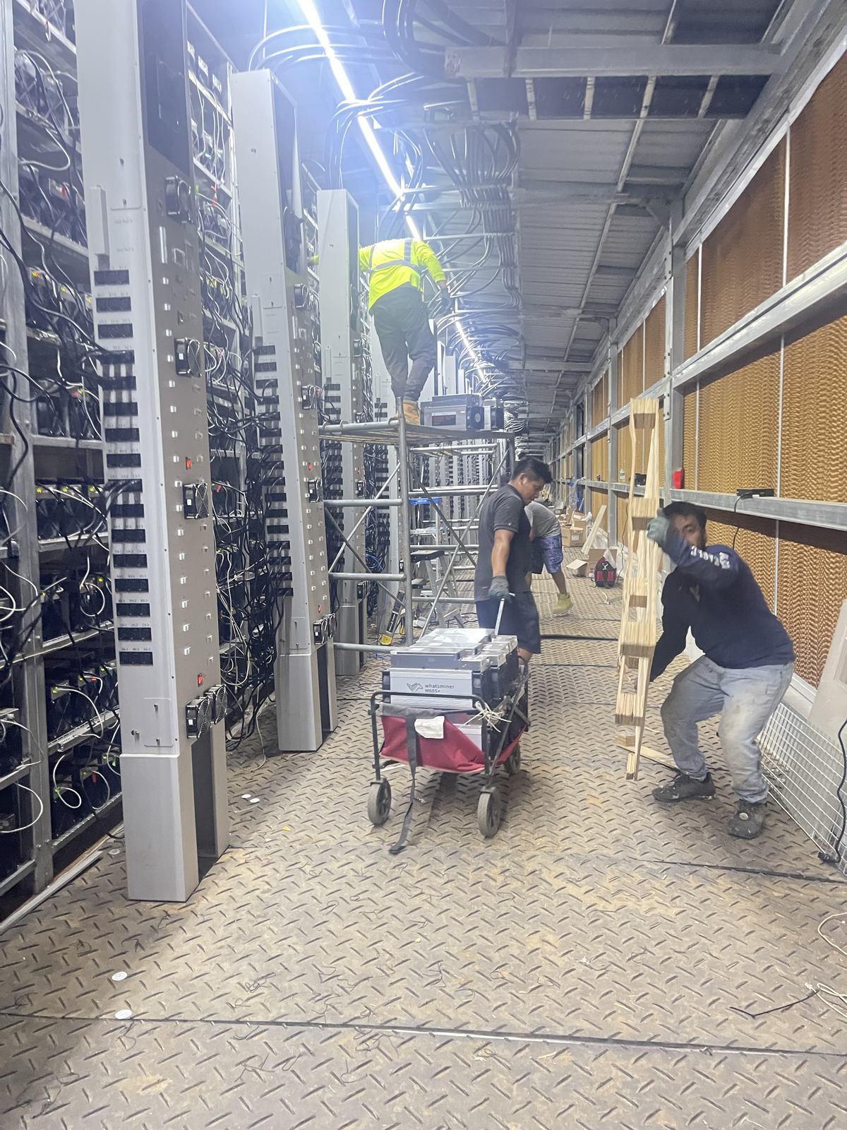 Technicians working inside an operating data center equipment enclosure