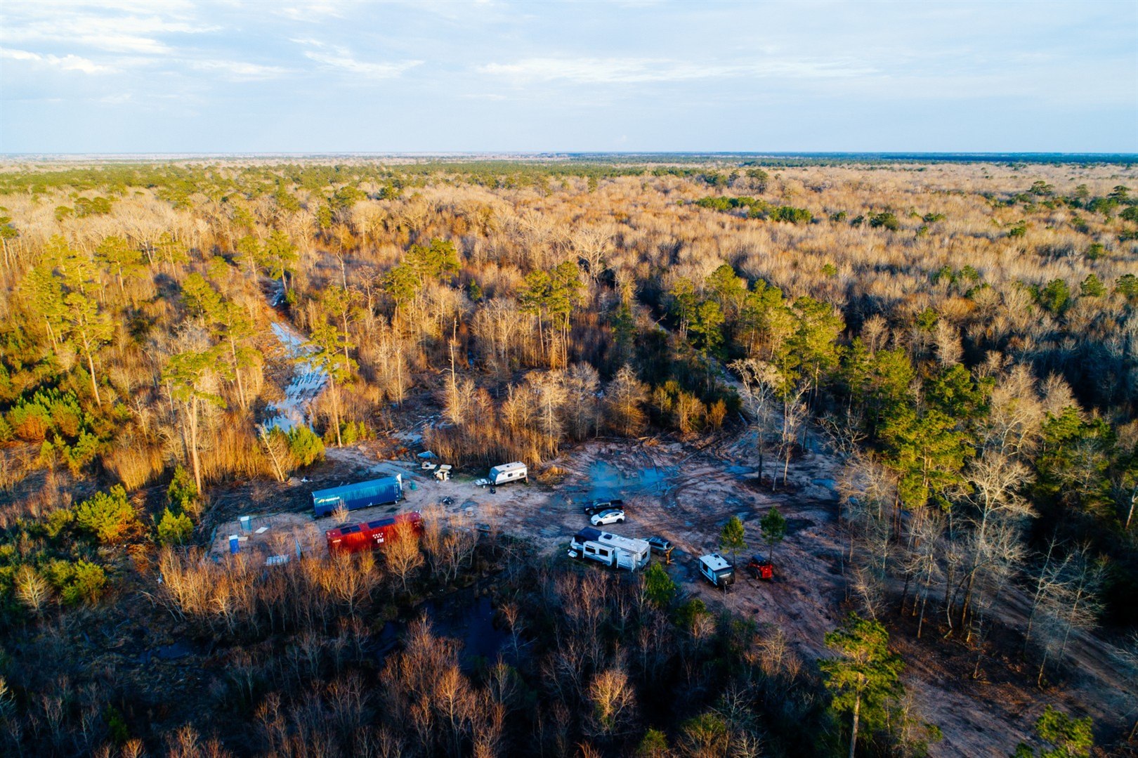 Aerial view of onsite construction crew RVs in a wooded project area